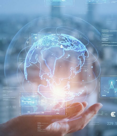 Hand holding a glowing digital globe with data analytics and global network connections — concept of artificial intelligence, innovation, and technology integration
